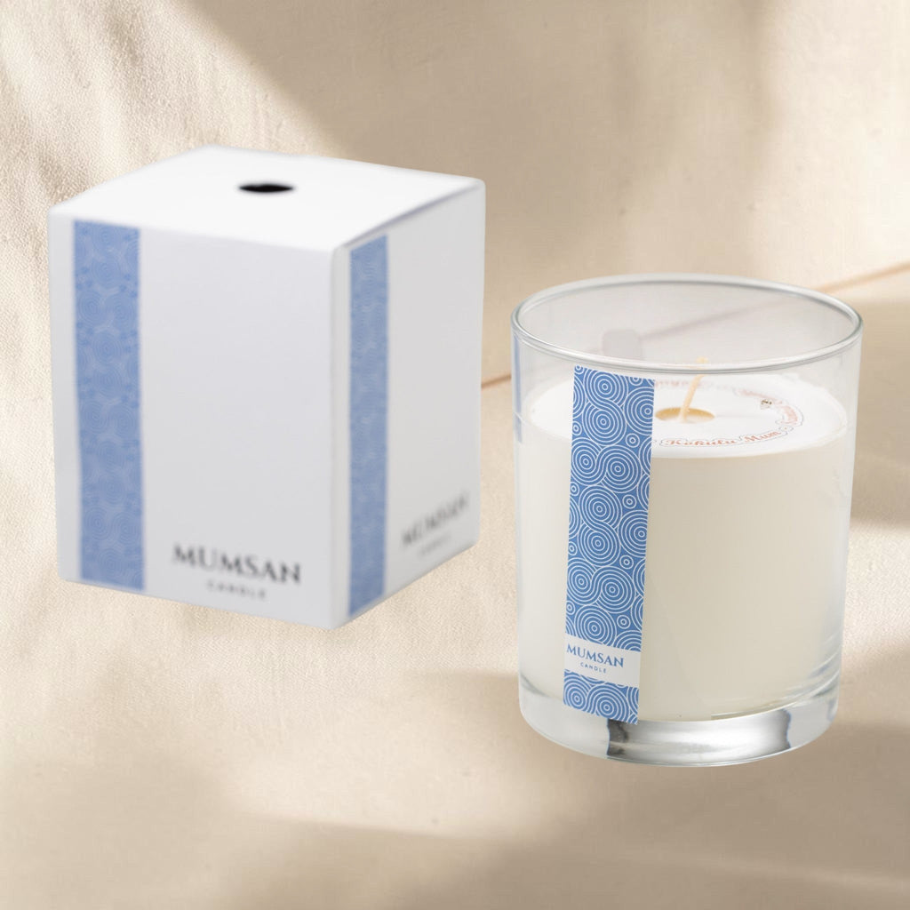 MUMSAN CANDLE Atina Bardak Mum, zarif cam bardakta, beyaz renkli, dekoratif ve hoş kokulu mum. Mavi desenli etiket.